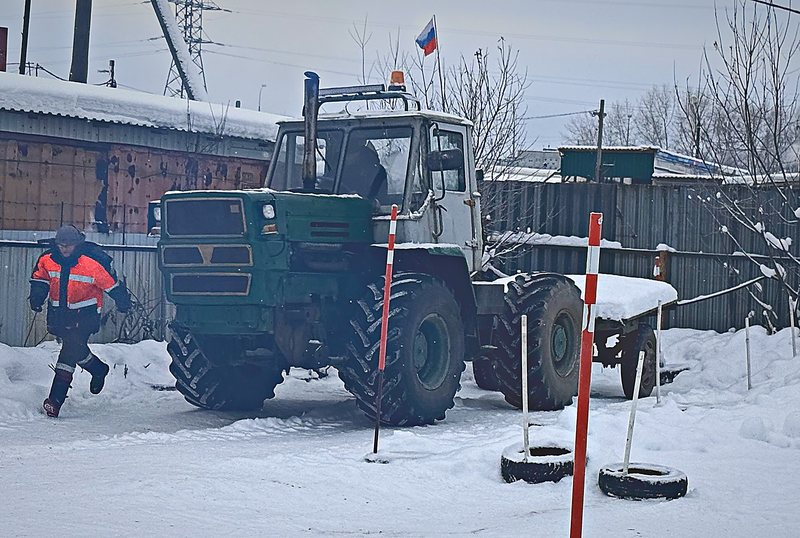 Колёсный трактор с прицепом на размеченной учебной площадке зимой, Архангельск